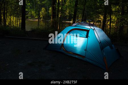 Une partie du mode de vie en plein air comprend souvent la randonnée à dos vers des campings éloignés, en particulier ceux dans les zones boisées près des plans d'eau, comme celui-ci. Banque D'Images