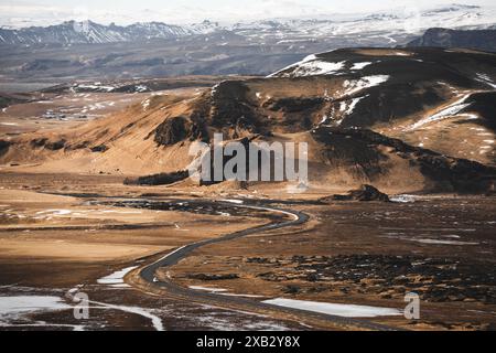 Une vue imprenable du paysage spectaculaire de la péninsule de Snaefellsnes en Islande, avec une route sinueuse qui traverse des collines arides et de la neige poussiéreuse de pla Banque D'Images