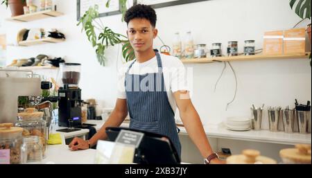 Café, portrait du barista et tablier avec le sourire pour la préparation du café, le service et derrière le comptoir pour interagir avec les clients. Propriétaire d'entreprise, employé Banque D'Images