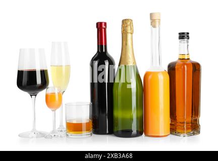 Bouteilles et verres avec différentes boissons alcoolisées isolées sur blanc Banque D'Images