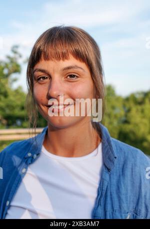 Portrait d'une jeune femme souriante avec une frange Banque D'Images