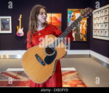 Londres, Royaume-Uni. 10 juin 2024. Un membre du personnel présente « The Martin 000-28 Flat-Top Acoustic Guitar », 1974, utilisé par Eric Clapton pour composer « Wonderful Tonight », sa chanson d’amour à Pattie Boyd (estimé à £300 000 - £400,000) lors d’une prévisualisation de la vente Rock, Pop & film de Bonhams. Les lots seront mis aux enchères le 12 juin dans les galeries Knightsbridge de Bonham. Credit : Stephen Chung / Alamy Live News Banque D'Images