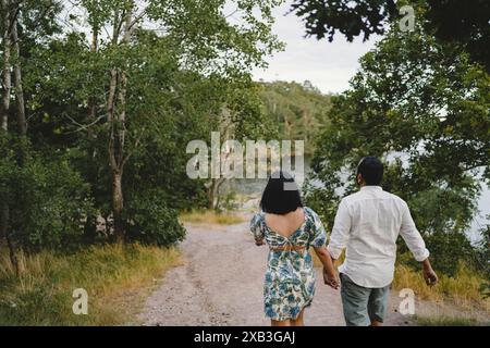 Couple holding hands and walking in park Banque D'Images