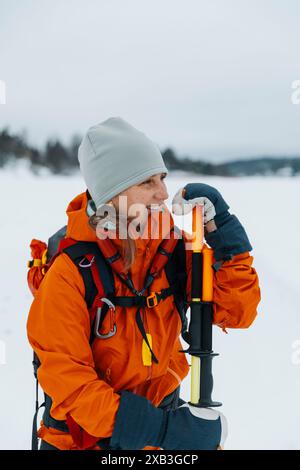 Femme heureuse avec des bâtons de randonnée en hiver Banque D'Images