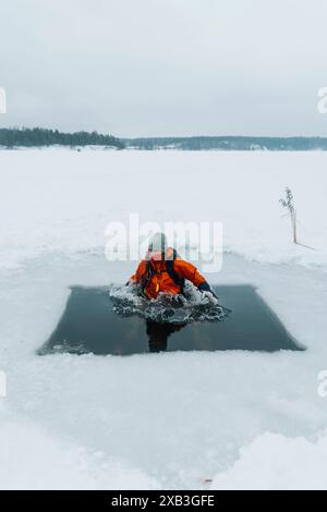 Femme à l'intérieur de l'eau gelée du lac couverte de neige Banque D'Images