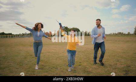 Mignon famille caucasienne week-end vacances heureux homme homme mâle père papa courir femme mère mère mère courir jouer petit garçon enfant fils jouant jouet Banque D'Images