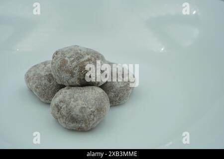 Mochi avec poudre blanche avec remplissage de chocolat et fond blanc Banque D'Images