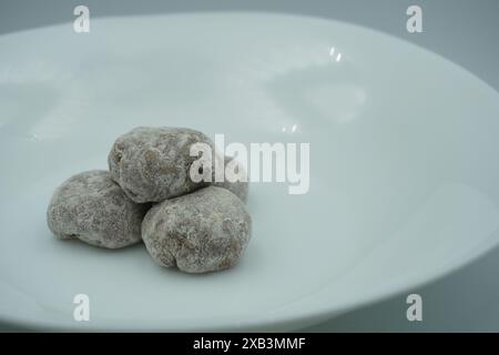 Mochi avec poudre blanche avec remplissage de chocolat et fond blanc Banque D'Images