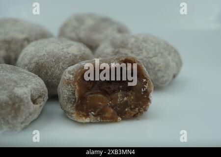 Mochi avec de la poudre blanche qui a été ouvert avec une garniture de chocolat et un fond blanc Banque D'Images
