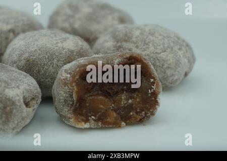 Mochi avec de la poudre blanche qui a été ouvert avec une garniture de chocolat et un fond blanc Banque D'Images