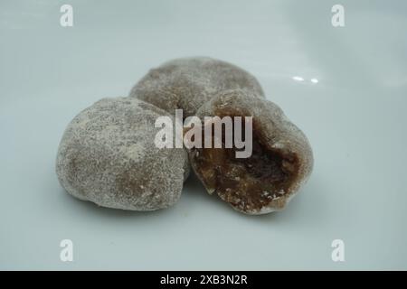 Mochi avec de la poudre blanche qui a été ouvert avec une garniture de chocolat et un fond blanc Banque D'Images