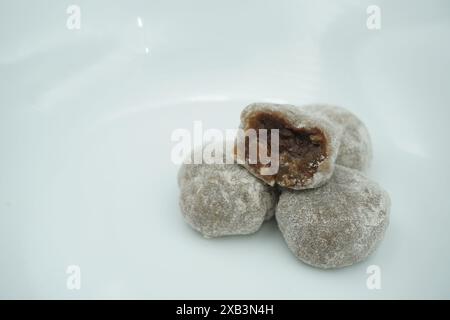 Mochi avec de la poudre blanche qui a été ouvert avec une garniture de chocolat et un fond blanc Banque D'Images