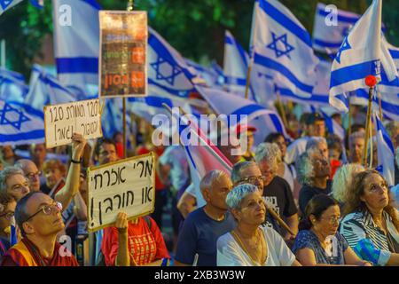 Haïfa, Israël - 08 juin 2024 : foule de personnes avec divers signes et drapeaux dans une Assemblée protester contre le gouvernement, appelant à de nouvelles élections. Banque D'Images