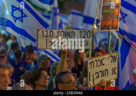 Haïfa, Israël - 08 juin 2024 : foule de personnes avec divers signes et drapeaux dans une Assemblée protester contre le gouvernement, appelant à de nouvelles élections. Banque D'Images