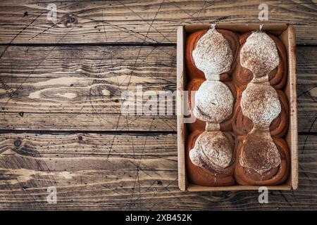 Kanelbulle petits pains à la cannelle avec crème au beurre sur une table en bois rustique. Viennoiseries maison, vue de dessus, espace photocopie. Banque D'Images