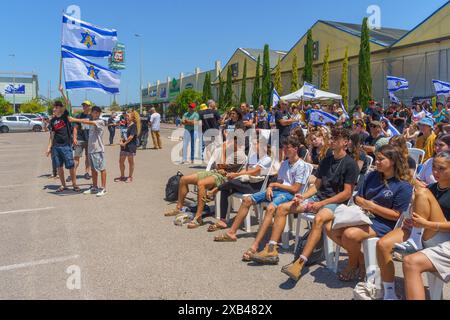 Yagur, Israël - 10 juin 2024 : foule de personnes avec divers signes et drapeaux dans une Assemblée de soutien aux familles d'otages, une partie de 120 véhicules conv Banque D'Images