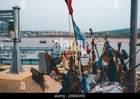 Drapeaux colorés Conway Harbour North Wales UK sur le quai avec des bateaux et des collines en arrière-plan Banque D'Images