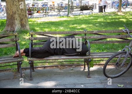 Homme sans-abri dort sur un banc à Foley Square à Center Street à Manhattan, New York. Banque D'Images