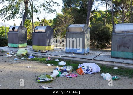 Sacs poubelle jetés et ouverts dans la rue à côté des poubelles et des bacs de recyclage. Vandalisme et incivilité des gens. Banque D'Images