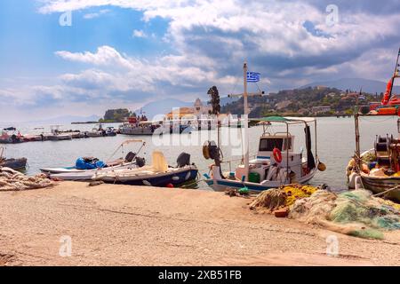 Bateaux de pêche amarrés près du monastère de Vlacherna à Corfou, Grèce, avec des collines en arrière-plan Banque D'Images