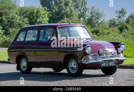 Stony Stratford, Royaume-Uni - 2 juin 2024 : 1965 marron Ford Anglia Estate voiture conduisant sur une route de campagne britannique Banque D'Images