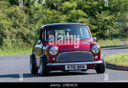 Stony Stratford, Royaume-Uni - 2 juin 2024 : 1998 Red Rover Mini Cooper voiture conduisant sur une route de campagne britannique Banque D'Images