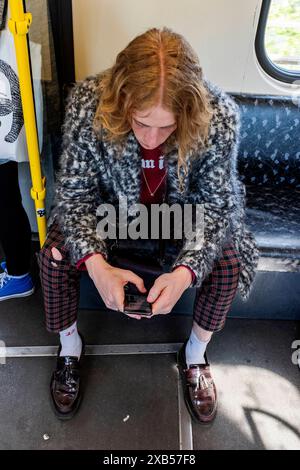 Lucas V / Leonard W jeune étudiant en musique adulte se déplaçant en métro à travers le Capitole allemand, en utilisant constamment son smartphone. Berlin, Allemagne. MRYES Berlin S-Bahn / U-Bahn train Berlin Allemagne Copyright : xGuidoxKoppesxPhotox Banque D'Images