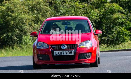 Stony Stratford, Royaume-Uni - 2 juin 2024 : 2007 voiture rouge Volkswagen Golf gti conduisant sur une route de campagne britannique Banque D'Images