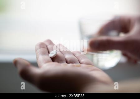 gros plan des mains tenant la pilule et un verre d'eau. Médecine pharmacie santé. gros plan d'un homme prenant des pilules, pov Banque D'Images