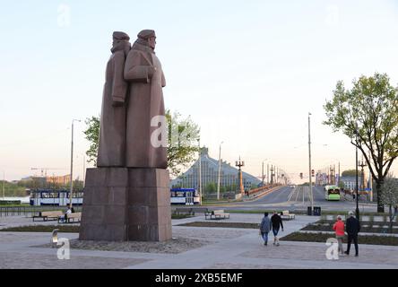 Le monument letton des tirailleurs devant le Musée de l'occupation, avec la Bibliothèque nationale au-delà, à Riga, Lettonie. Banque D'Images