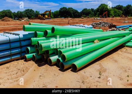 Des tuyaux en PVC vert sont utilisés sur les chantiers de construction pour la pose de conduites d'eau pour les nouvelles maisons Banque D'Images