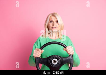 Portrait photo de belle femme retraitée conduisant voiture nerveuse tenue verte tendance isolée sur fond de couleur rose Banque D'Images