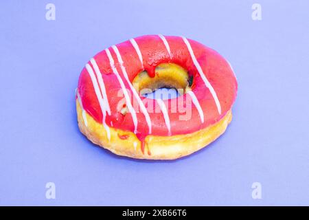 Donut simple avec garniture posée sur un fond bleu. Banque D'Images