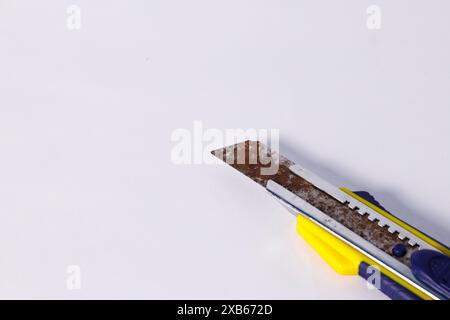 Vieux couteau de coupe avec manche en plastique rouillé isolé sur blanc Banque D'Images