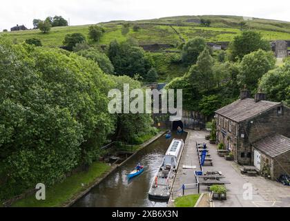 Les canoéistes sortent du tunnel Standedge sur le canal étroit Huddersfield, décrit comme l'une des sept merveilles des voies navigables britanniques, le tunnel, long de près de trois miles et demi, il a fallu plus de 17 ans pour creuser à la main et a été achevé en 1811, devenant le tunnel de canal le plus long, le plus profond et le plus haut du Royaume-Uni à 645 pieds au-dessus du niveau de la mer, creusant quelque 638 pieds sous les Pennines. Date de la photo : lundi 10 juin 2024. Banque D'Images