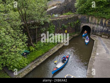 Les canoéistes sortent du tunnel Standedge sur le canal étroit Huddersfield, décrit comme l'une des sept merveilles des voies navigables britanniques, le tunnel, long de près de trois miles et demi, il a fallu plus de 17 ans pour creuser à la main et a été achevé en 1811, devenant le tunnel de canal le plus long, le plus profond et le plus haut du Royaume-Uni à 645 pieds au-dessus du niveau de la mer, creusant quelque 638 pieds sous les Pennines. Date de la photo : lundi 10 juin 2024. Banque D'Images