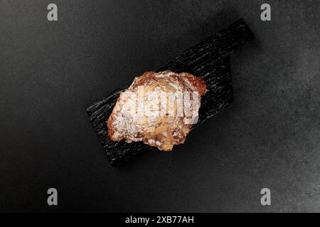 Croissant aux amandes. pâte feuilletée, délicate crème frangipane aux amandes, enrichie de beurre. Sur le dessus, le croissant a un soupçon de flocons d'amande et de pow Banque D'Images