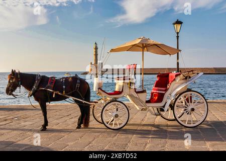 Cheval et calèche avec le port vénitien et le phare en arrière-plan, la Canée, Crète, Grèce Banque D'Images