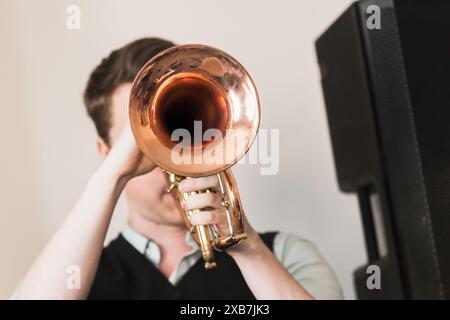 Trompettiste avec une trompette dans les mains, photo de face en gros plan avec mise au point sélective. Fond de musique live Banque D'Images