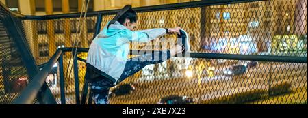 Bannière de jeune athlète femme brune étirant ses jambes sur la rampe de pont avant de courir sur la ville la nuit. Coureuse s'échauffant le soir au remorquage Banque D'Images
