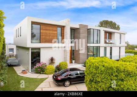 Une maison contemporaine de deux étages dans un cadre ensoleillé avec voiture garée devant Banque D'Images