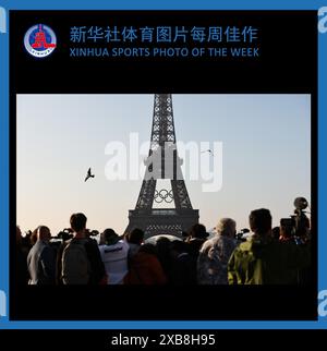 (240611) -- PÉKIN, 11 juin 2024 (Xinhua) -- PHOTO SPORTIVE DE LA SEMAINE XINHUA (du 3 au 9 juin 2024) TRANSMISE le 11 juin 2024. Les gens regardent les anneaux olympiques sur la Tour Eiffel, à Paris, France, le 7 juin 2024. Les anneaux olympiques sont dévoilés sur la Tour Eiffel tôt le matin de vendredi alors que la capitale française marque 50 jours avant le début des prochains Jeux Olympiques de Paris 2024. (Xinhua/Gao Jing) Banque D'Images