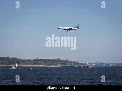 Un JetBlue Airbus 321 survole la mer avant d'atterrir à Boston après avoir volé de San Francisco Banque D'Images