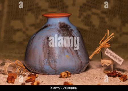 Vase en céramique rustique fait à la main avec des herbes séchées et des bouteilles en verre Banque D'Images