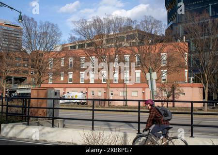 Un homme faisant du vélo dans une rue de la ville avec des bâtiments en arrière-plan Banque D'Images