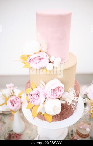 Un plan vertical d'un gâteau rose superposé orné de fleurs Banque D'Images