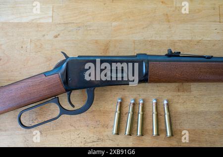 Détail d'un vieux fusil à levier winchester de l'extrême ouest et sauvage avec quelques balles de calibre 30-30 sur une table en bois Banque D'Images