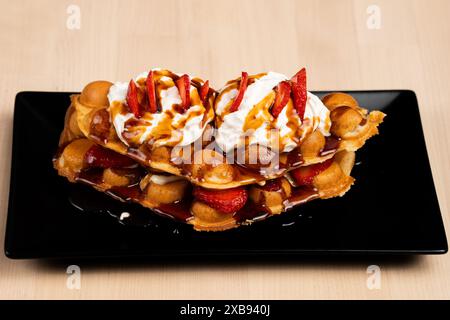 Un délicieux dessert avec gaufres, fraises et sirop Banque D'Images