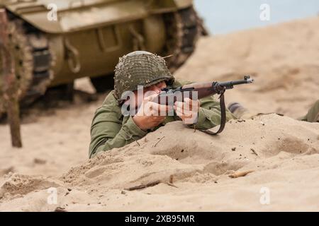 Reconstruction historique. Un soldat d'infanterie américain de la seconde Guerre mondiale combattant sur la plage. Banque D'Images