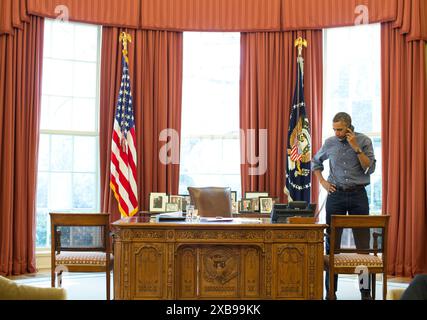 Le président Barack Obama s’entretient au téléphone dans le bureau ovale avec le président russe Vladimir Poutine de la situation en Ukraine. (Photo officielle de la Maison Blanche par Pete Souza) Banque D'Images